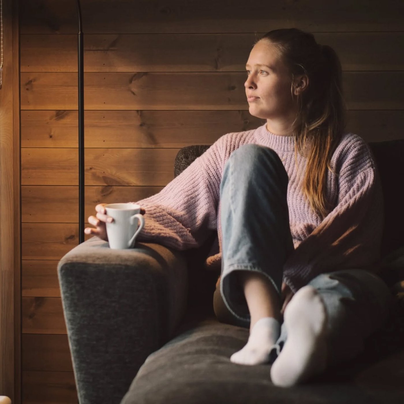 Portrett av en kvinne som slapper av i en lenestol med en kopp kaffe